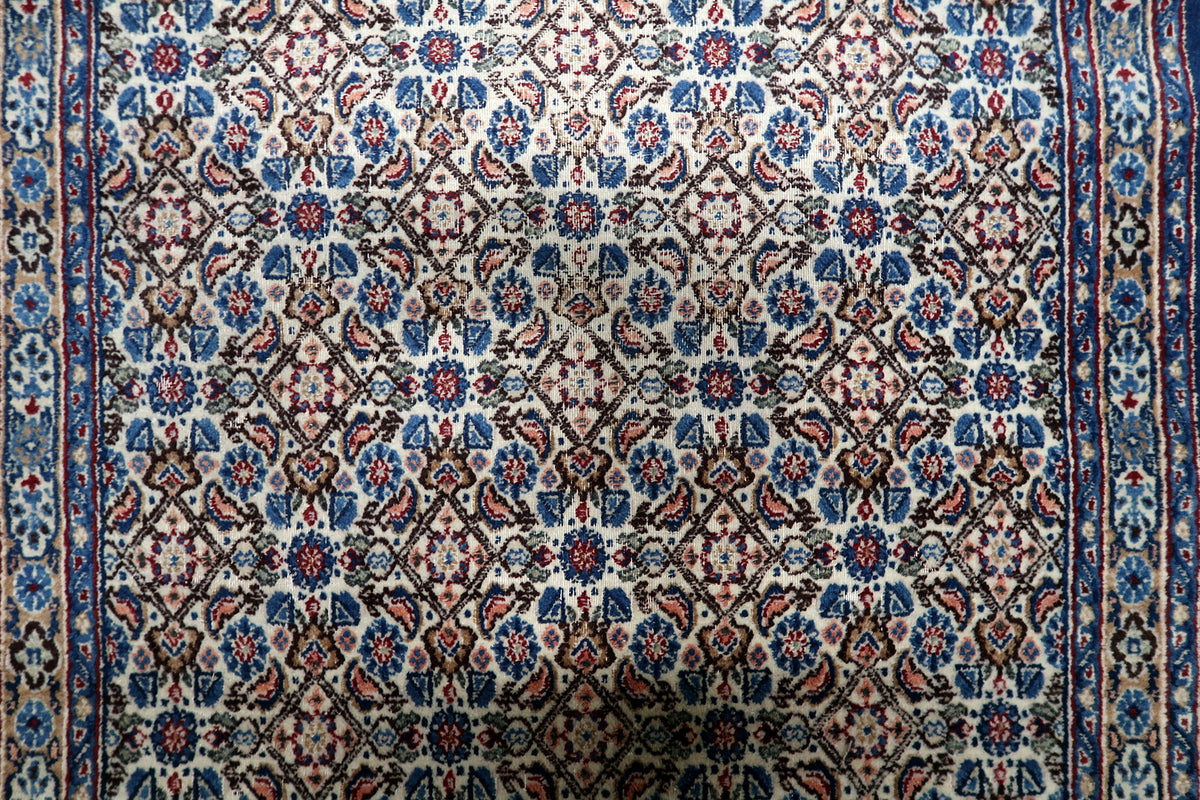 Authentic mid-century Persian wool rug woven with intricate botanical motifs, floral meanders, and traditional borders.