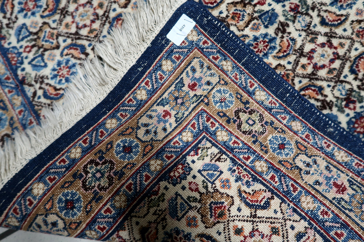 Soft ivory, royal navy blue, slate blue, and warm accent tones on an antique-style 1950s handmade wool rug.