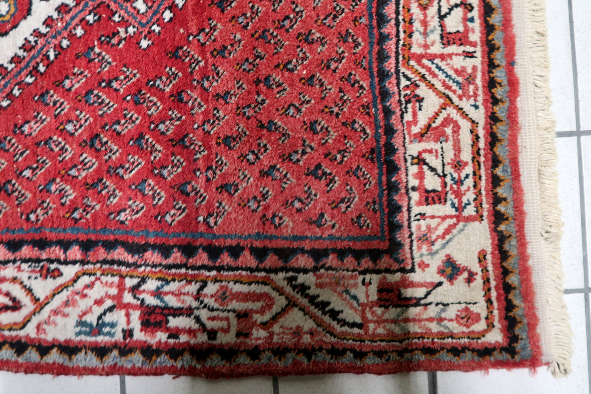 Hand-knotted 1950s oriental accent rug displaying a central star medallion with intricate floral spandrels and traditional borders.