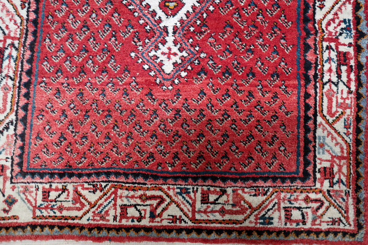 Mid-century vintage Indian wool carpet with rich red, ivory, and deep navy blue color palette and natural fiber sheen.