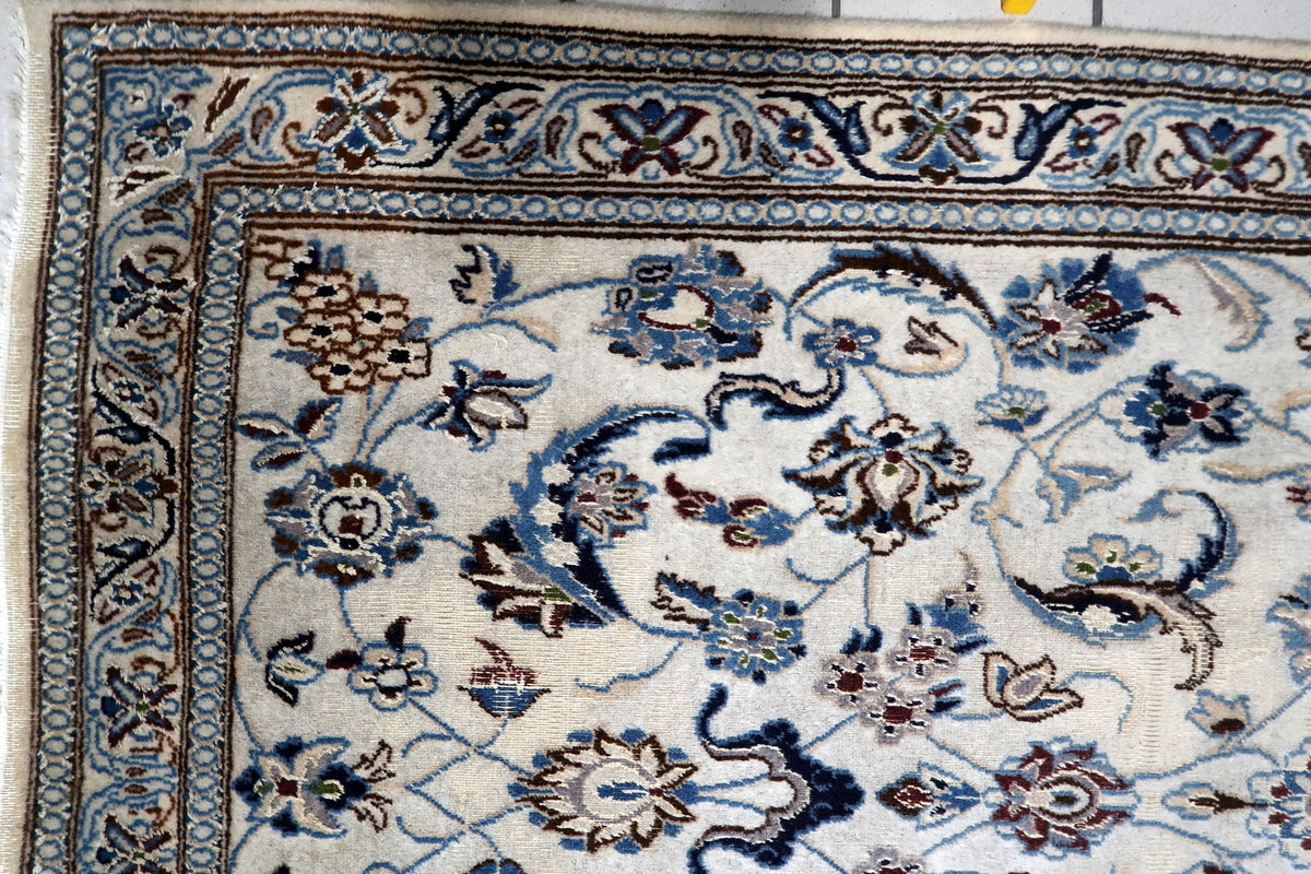 Detailed central floral field layout framed by ornamental corner spandrels and trailing vine scrollwork in navy and ivory.