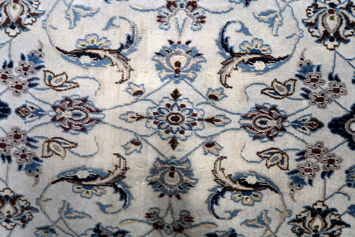 Hand-spun wool pile woven with natural vegetable dyes showing soft abrash color variation and shimmering silk accents.