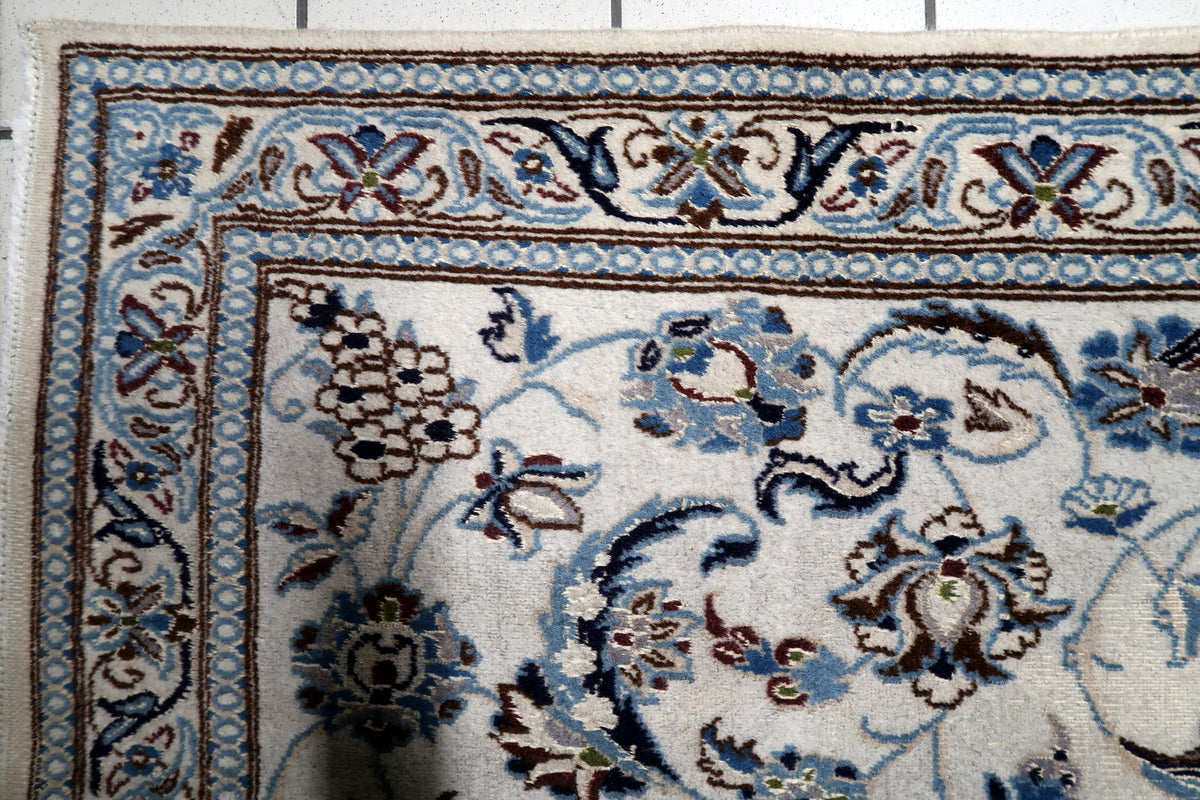 Soft ivory, royal navy blue, slate blue, and luminous silk highlights on an antique-style 1950s handmade rug.