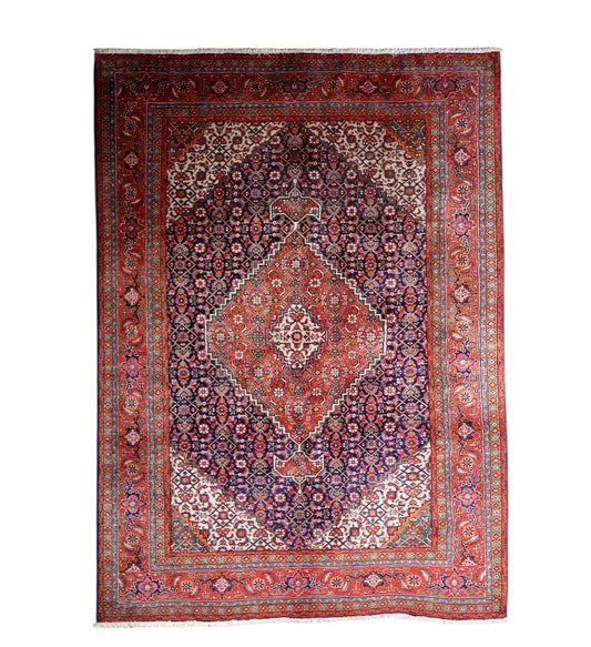 Vintage 1940s handmade wool area rug featuring a classic central medallion design on a rich red and navy blue field (Ref: 1C1301).