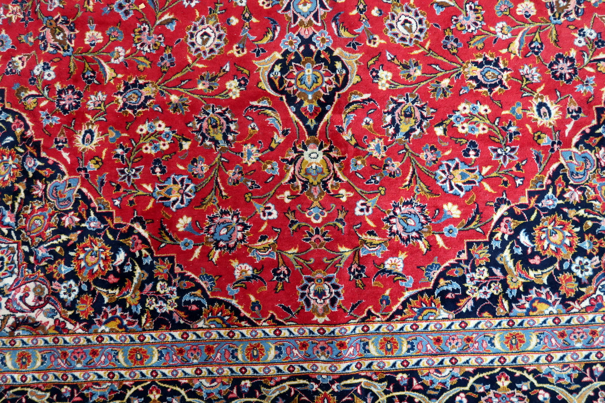 Floral pendant on the red field between navy scalloped corners