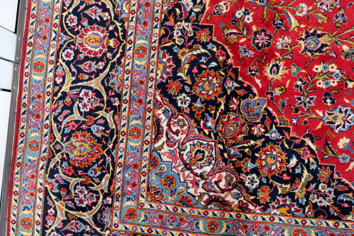 Large navy palmette border beside a layered ivory and sky-blue floral corner