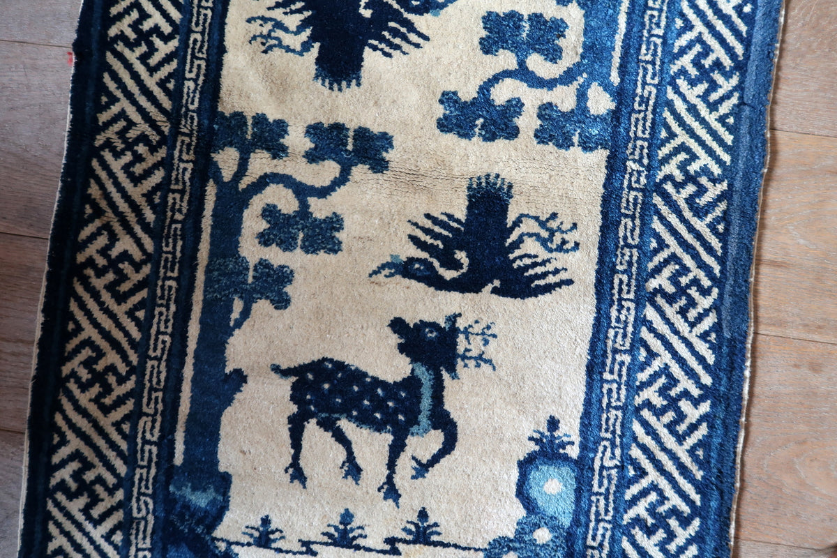 Ivory field with spotted deer, outstretched bird and visible horizontal pile wear