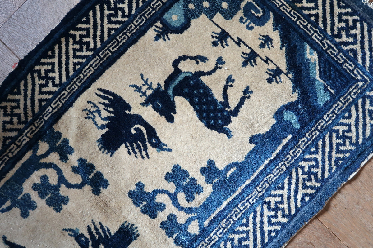 Angled pictorial field showing deer, bird and stylised trees within geometric borders