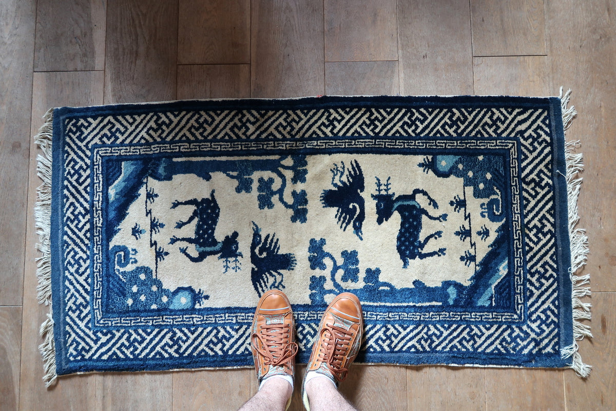 Overall view of the blue-and-ivory rug with paired deer and birds