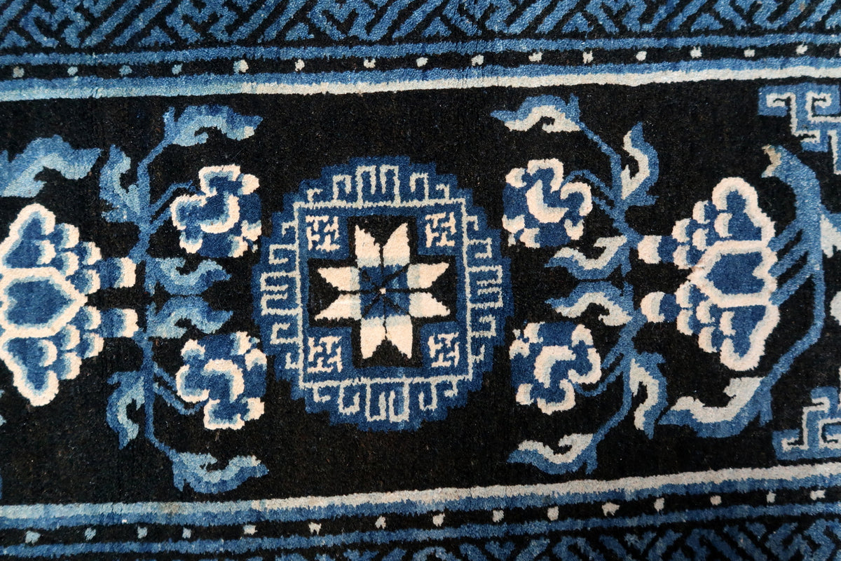 Symmetrical flowering stems surrounding the stepped floral medallion