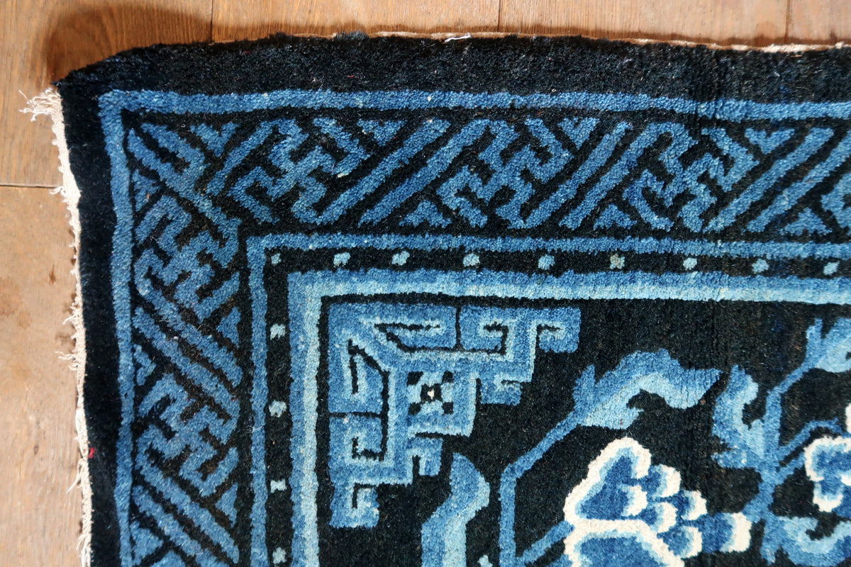 Close-up of blue fretwork border and frayed end with exposed light threads