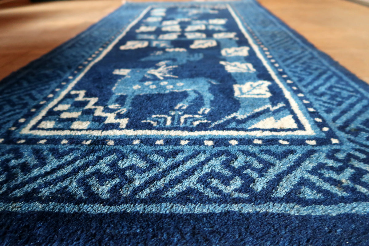 Low-angle view of wool surface, spotted deer and broad blue geometric border