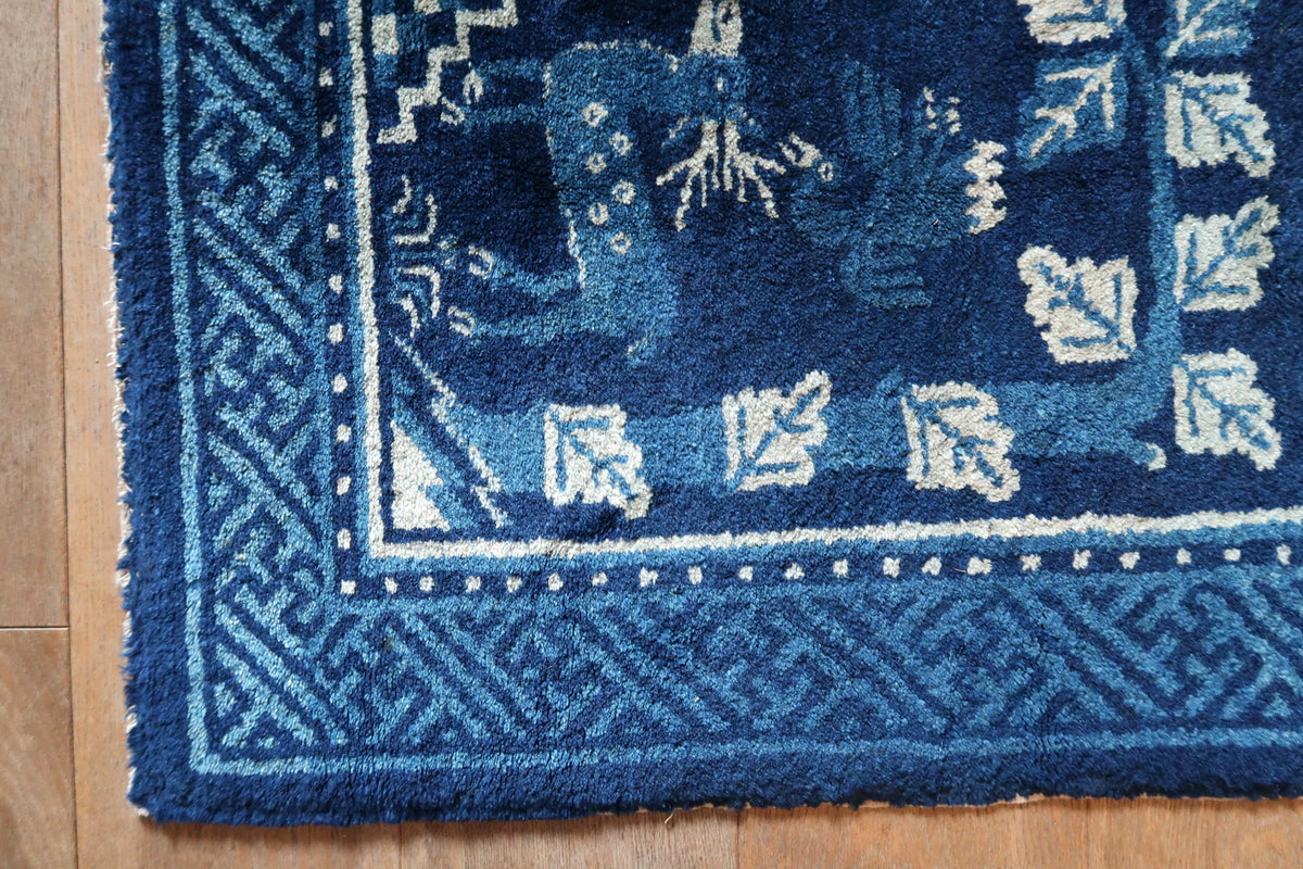 Angled end detail with spotted deer, ivory leaves and blue geometric border