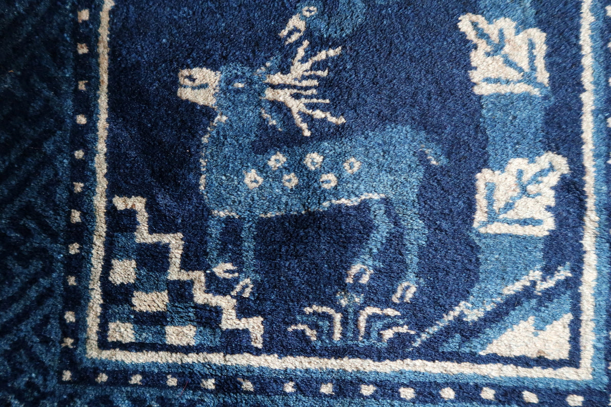 Close-up of blue deer with pale spots and ivory antlers beside stepped corner ornament