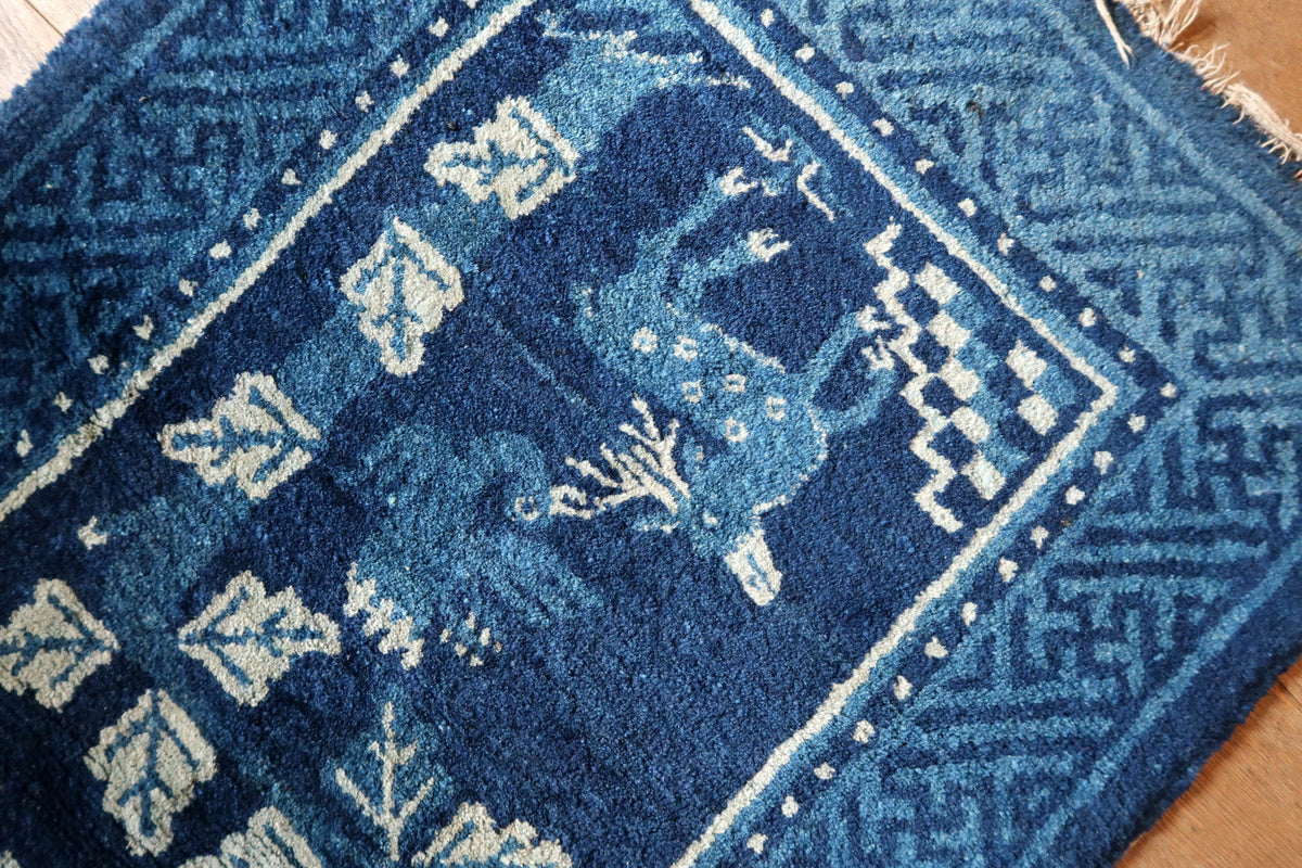 Angled deer motif with ivory spots, stepped corner detail and uneven fringe at the end
