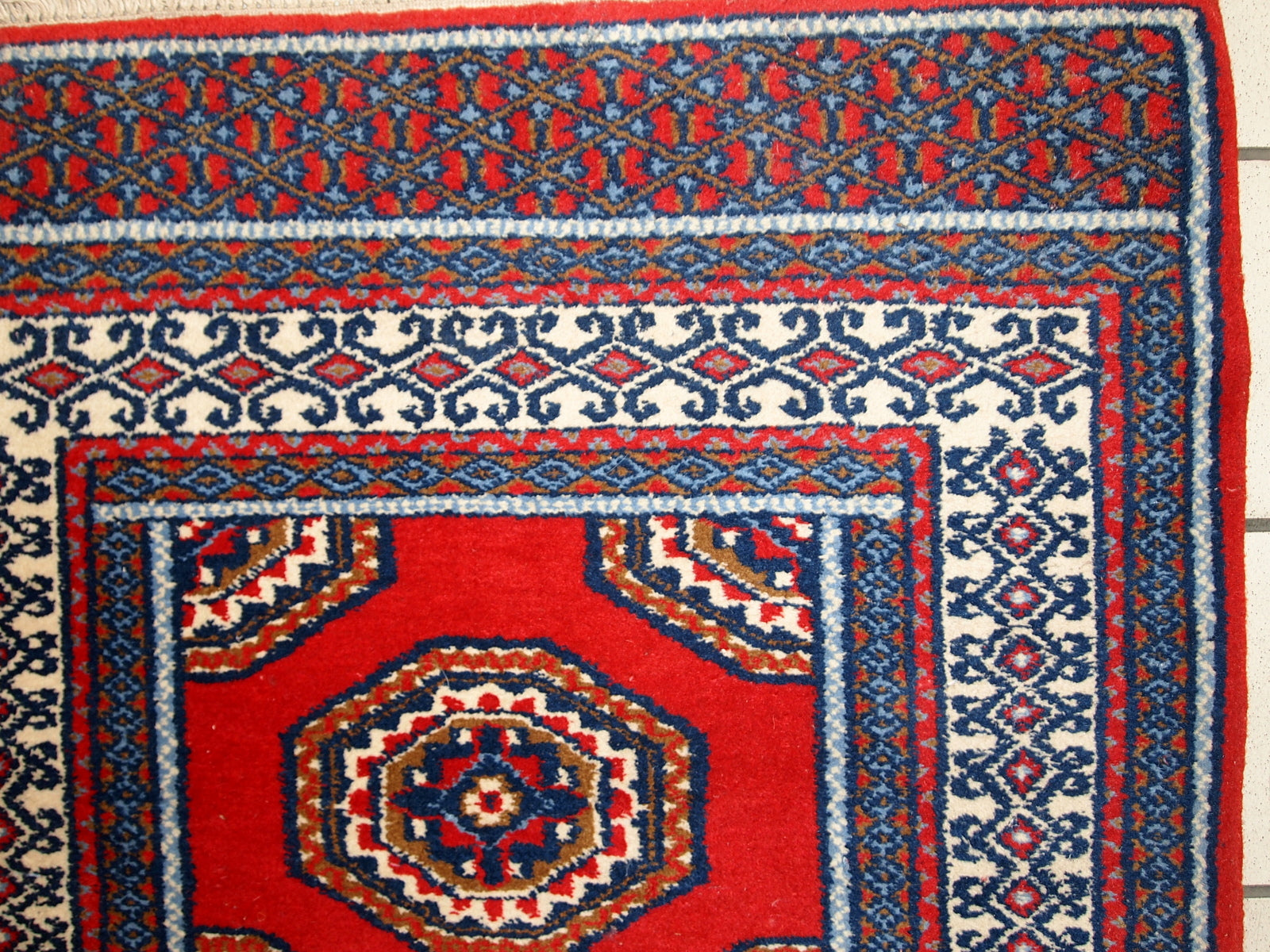 Detailed floral pattern of the vintage Indo-Mahal rug in red and blue hues.

