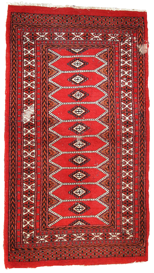 Handmade vintage Pakistani Lahore rug with distressed red wool and multi-colored patterns.

