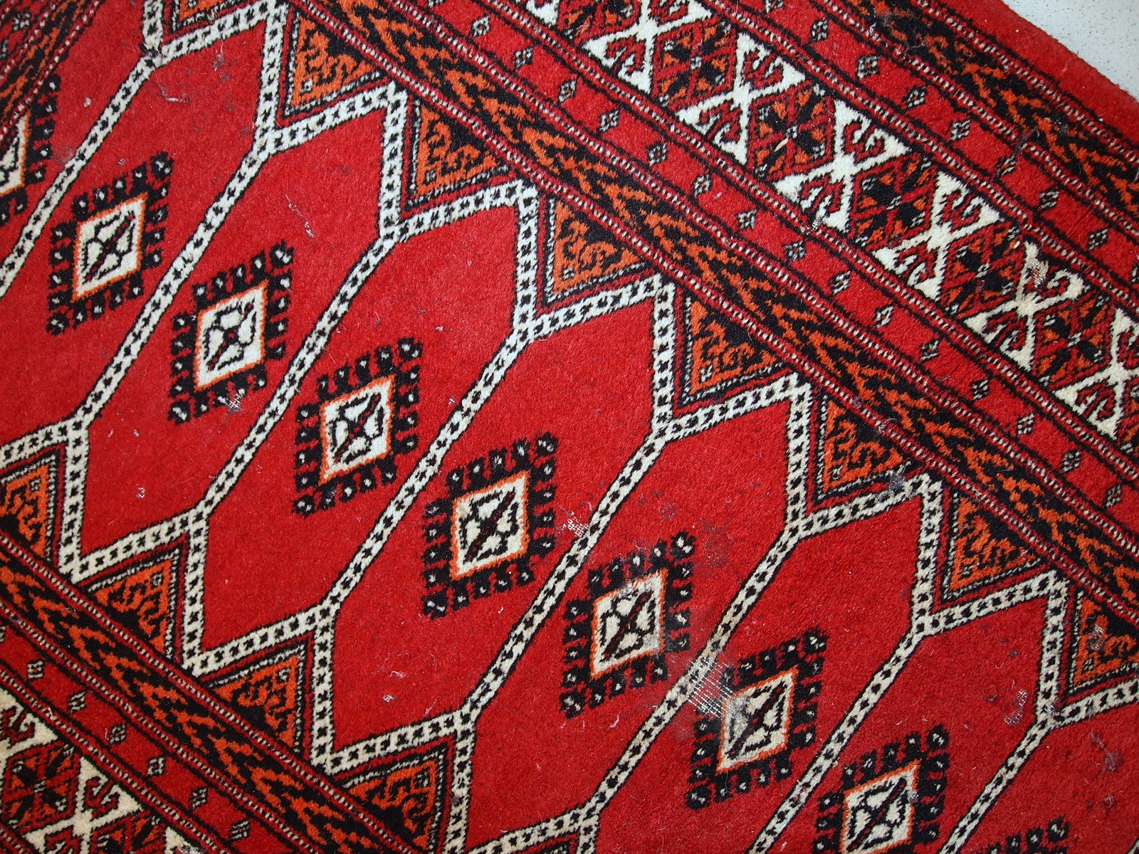Vintage 1960s Lahore rug with vibrant colors including red, white, pink, and orange.


