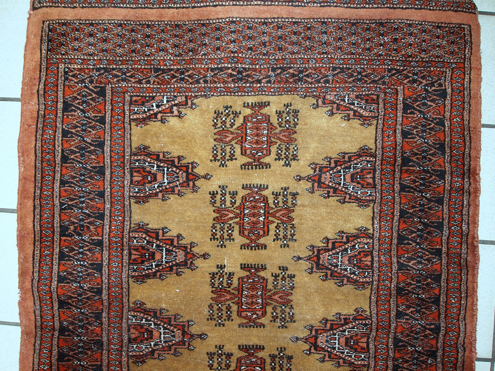 Vintage Uzbek Bukhara rug showing the geometric pattern in yellow, red, and navy.

