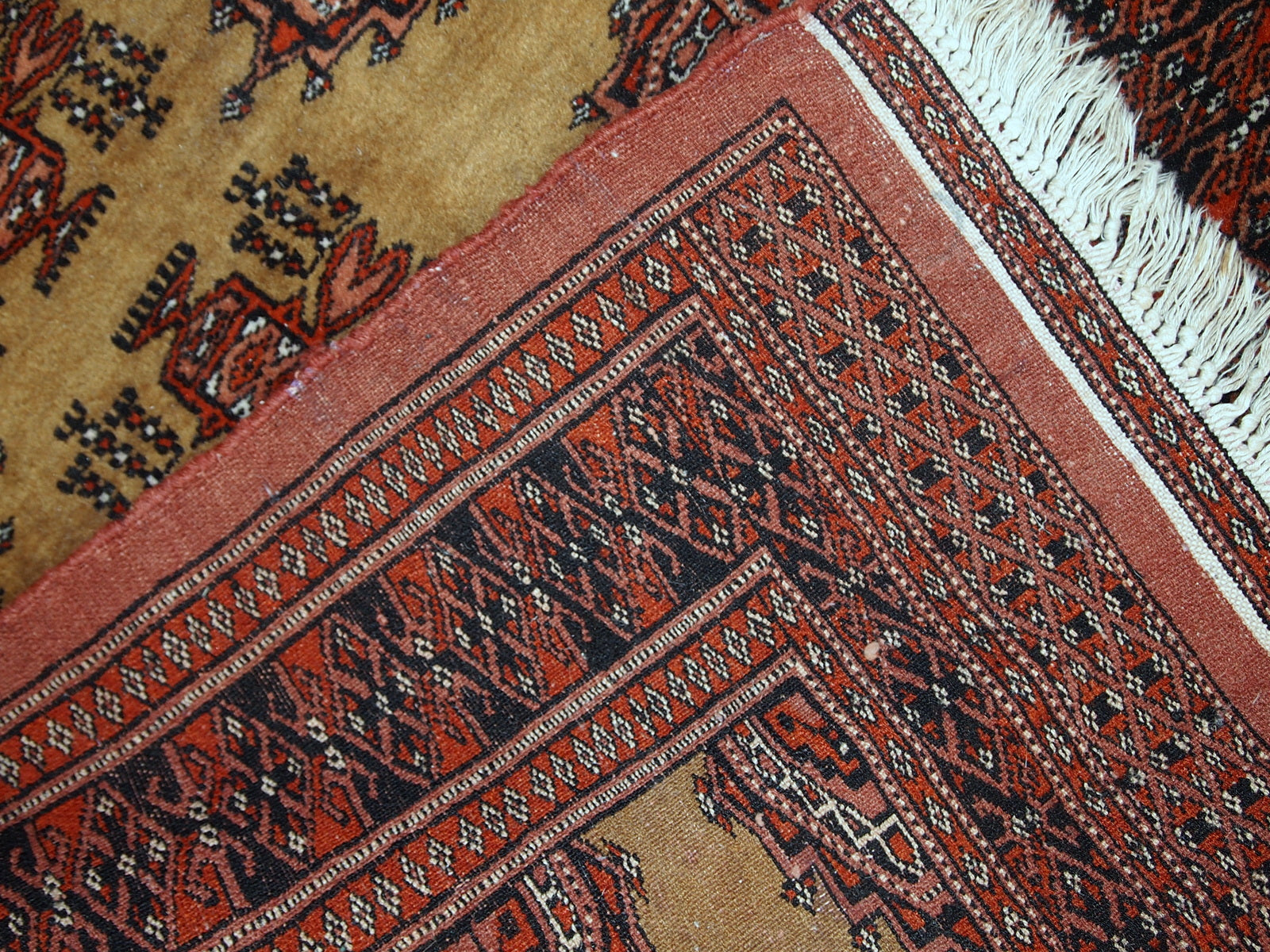 Close-up of the original condition and minor signs of age wear on the Bukhara rug.

