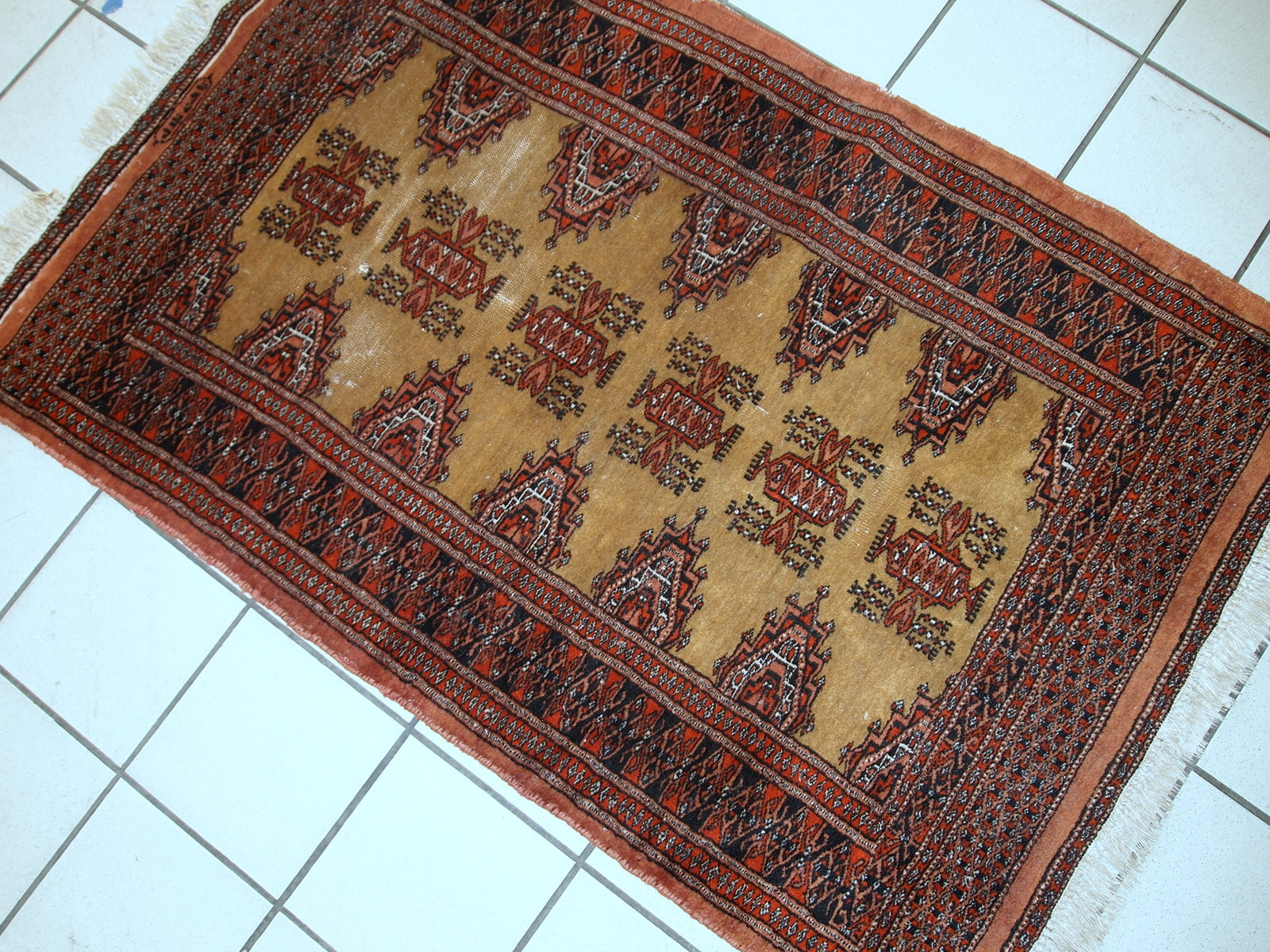 Traditional Uzbek wool Bukhara rug with rich colors of yellow, red, orange, and navy.

