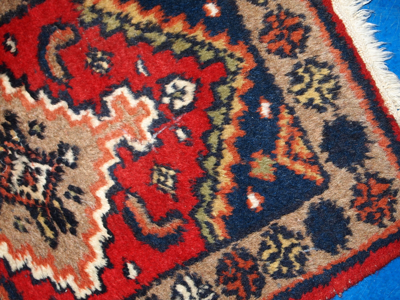 Detailed shot of the 1970s Hamadan style rug, highlighting the geometric patterns and warm colors.

