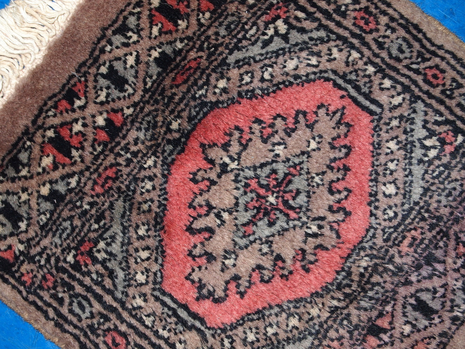 Detailed view of burgundy pattern on Uzbek rug

