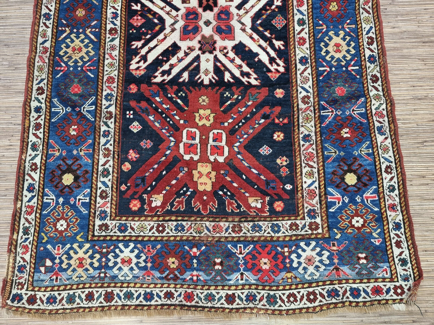 Detailed view of the intricate border design of the Kazak rug
