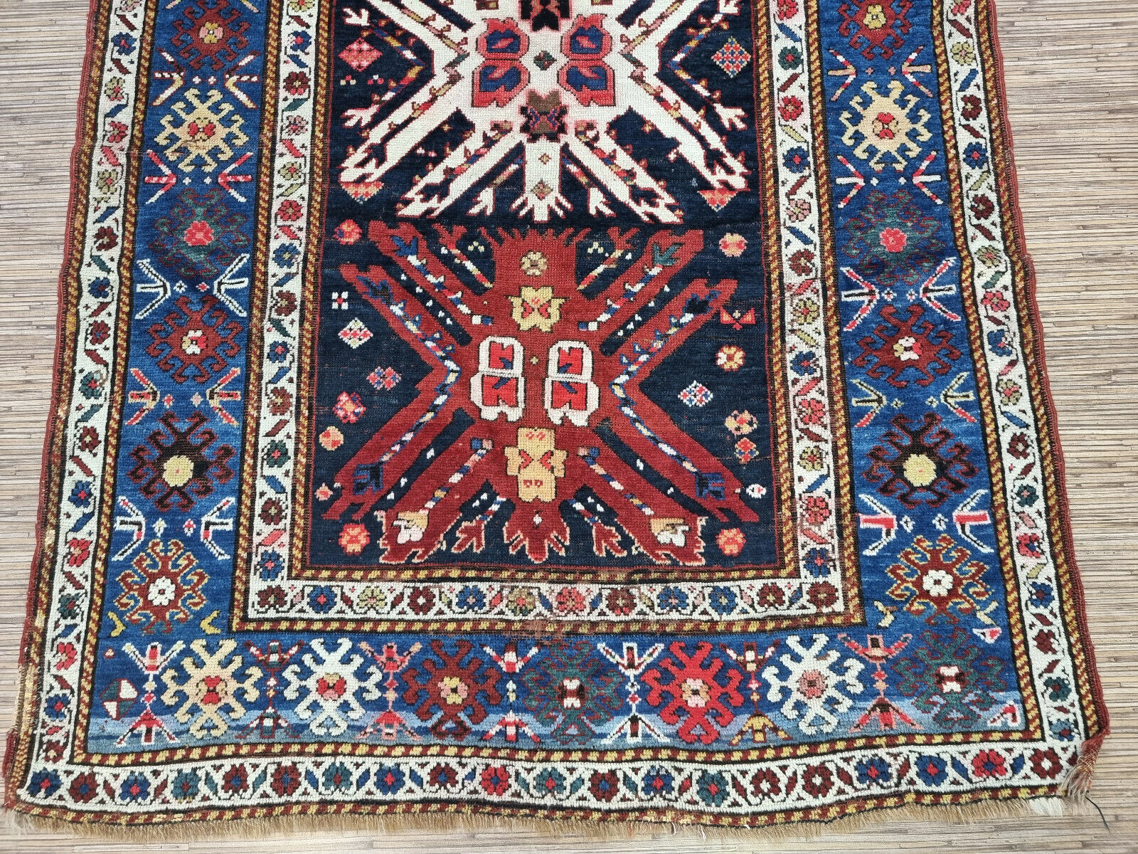 Detailed view of the intricate border design of the Kazak rug
