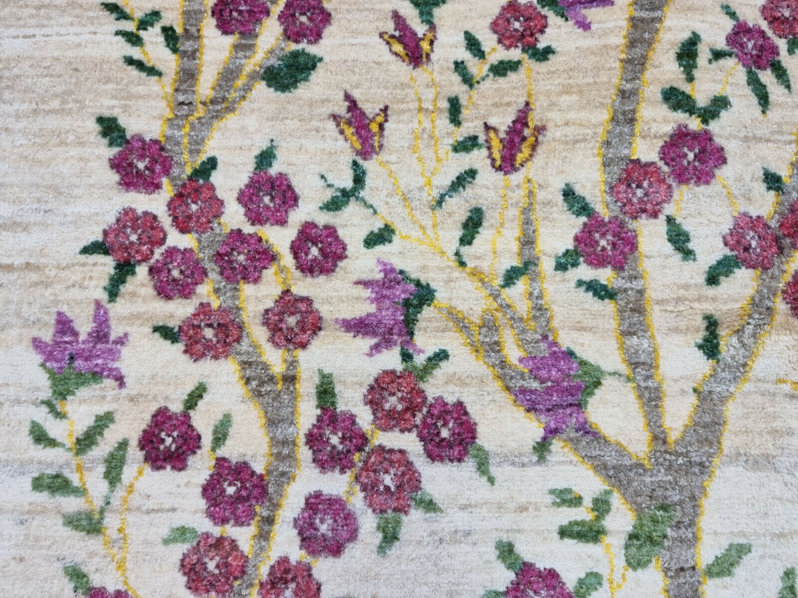 Detailed view of the green hillocks at the base of the Persian Gabbeh rug
