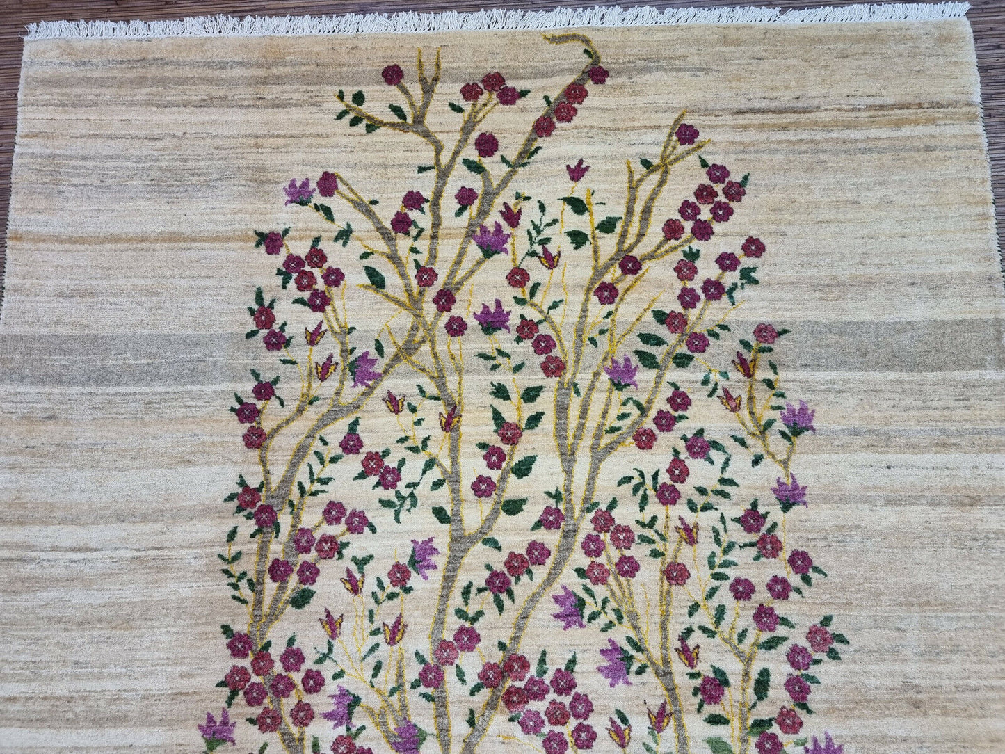 Beige background with vibrant floral accents on the Gabbeh rug
