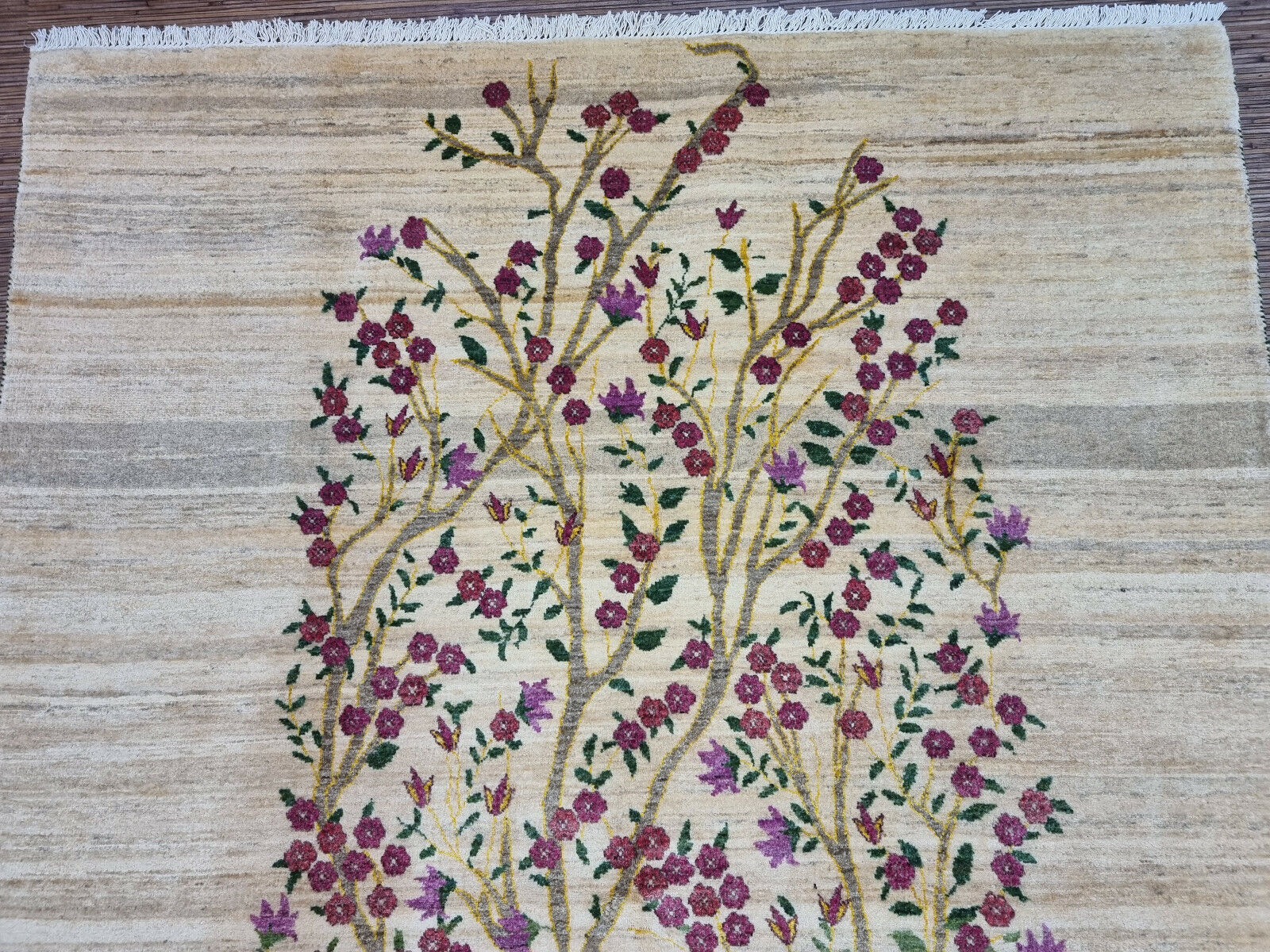 Beige background with vibrant floral accents on the Gabbeh rug
