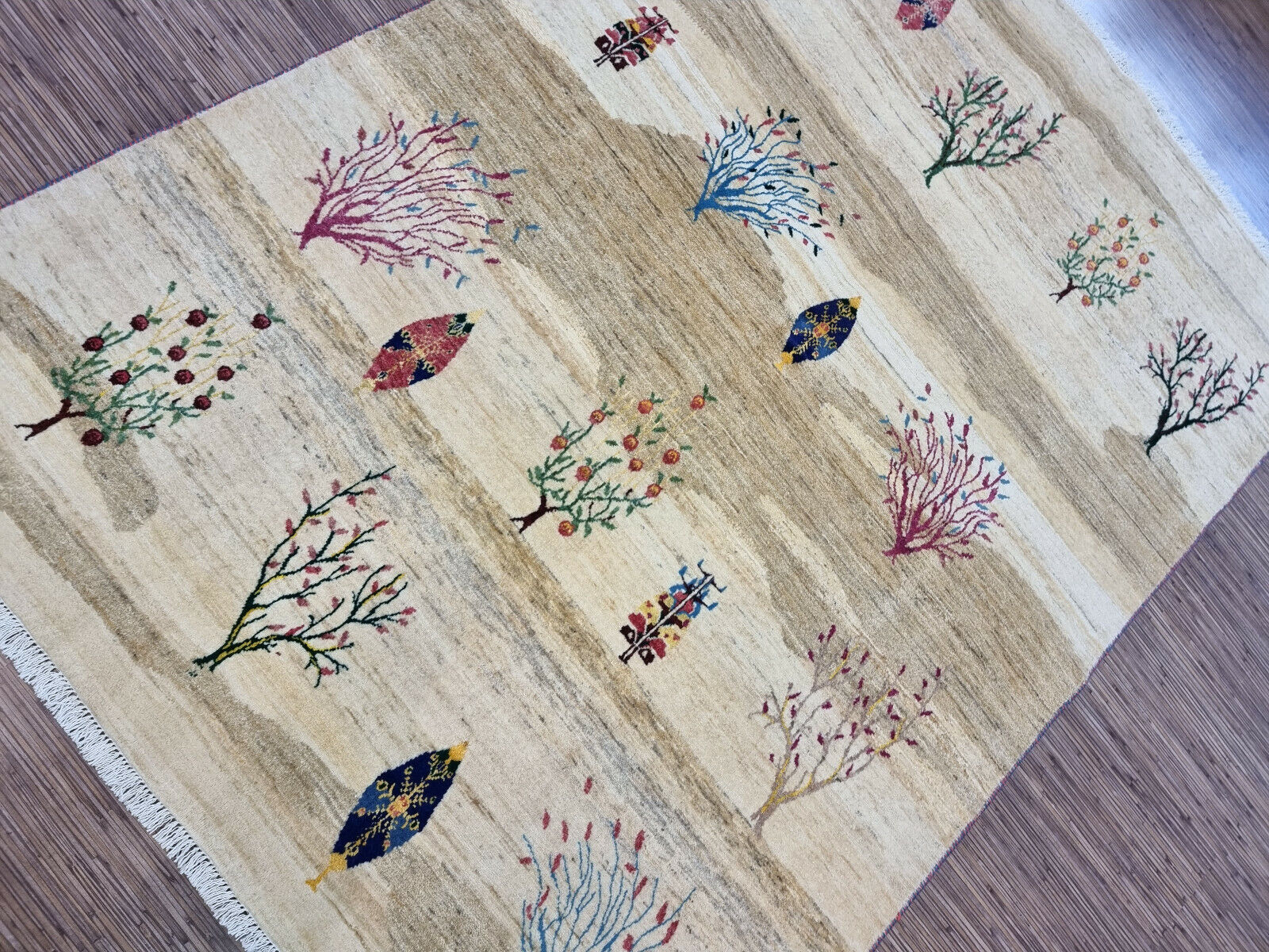 Beige background with colorful tree designs on the Persian rug

