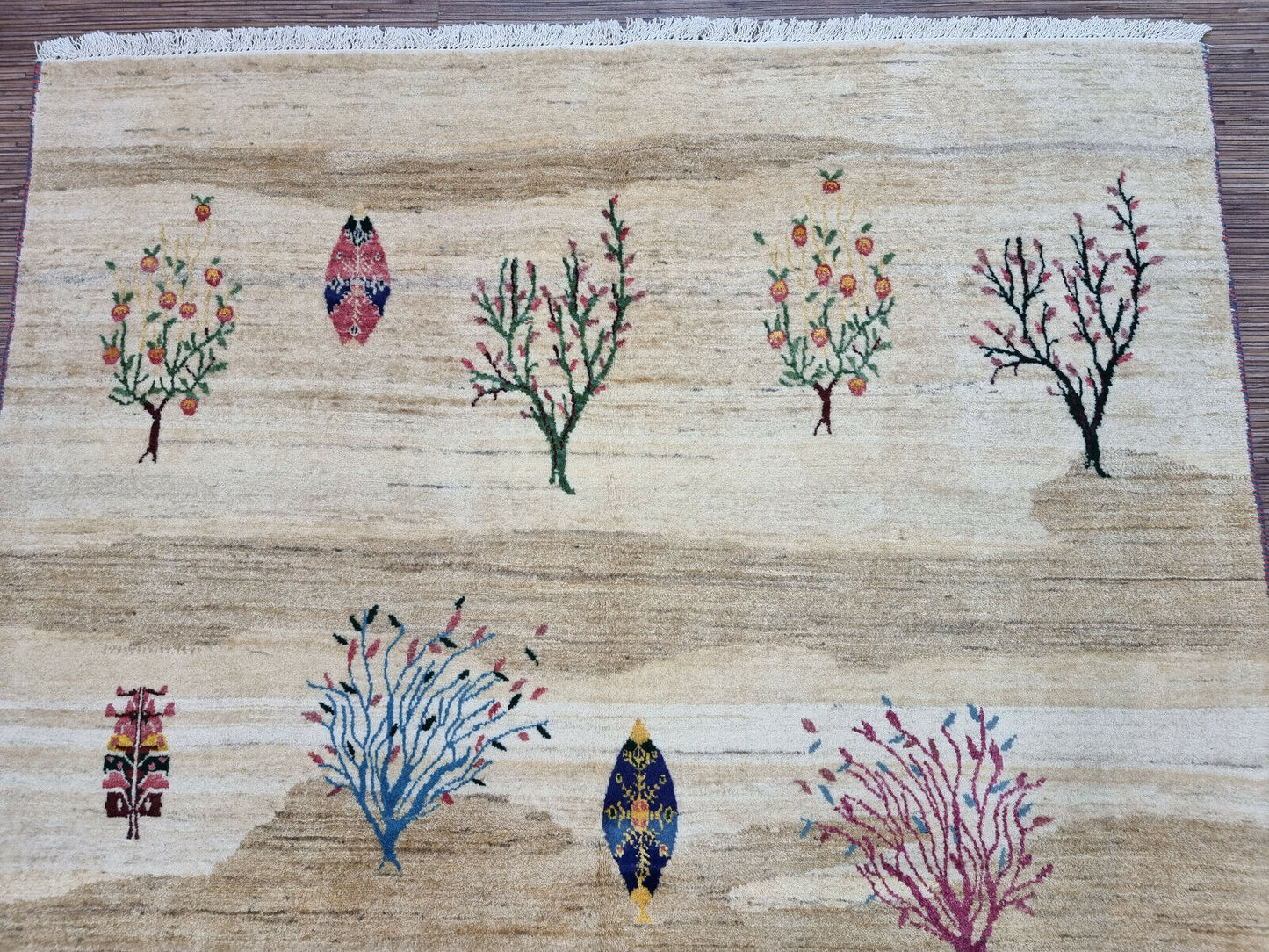 Overview of the rug’s vibrant tree motifs on a neutral beige background
