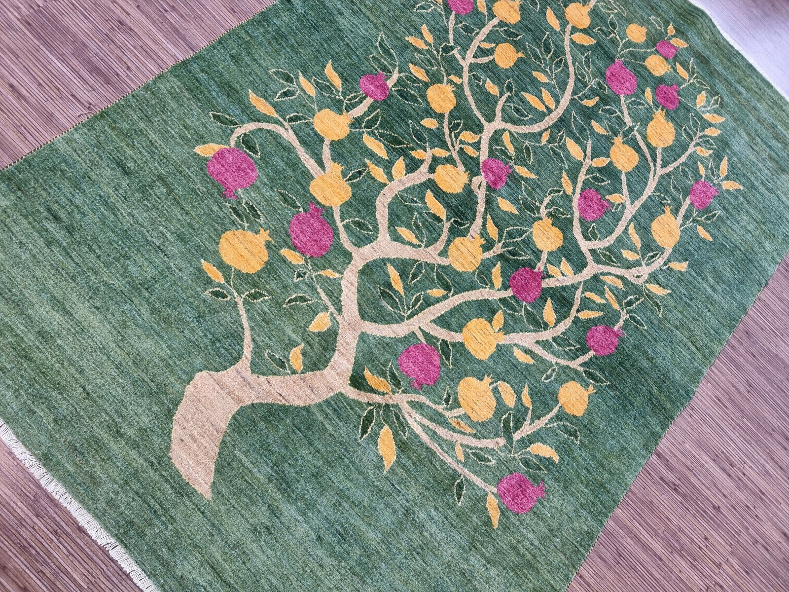 Central tree design on the Persian Gabbeh rug with yellow and pink flowers
