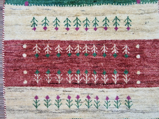 Close-up of hand-knotted tree motif on Persian Gabbeh rug

