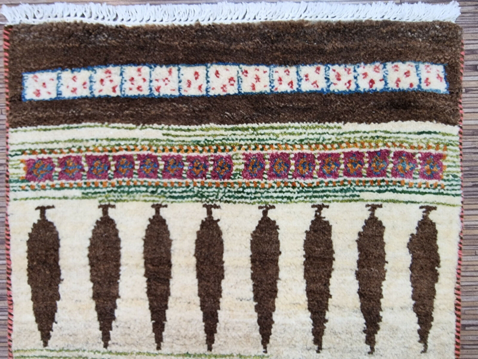 Rectangular Persian Gabbeh rug displayed on hardwood flooring

