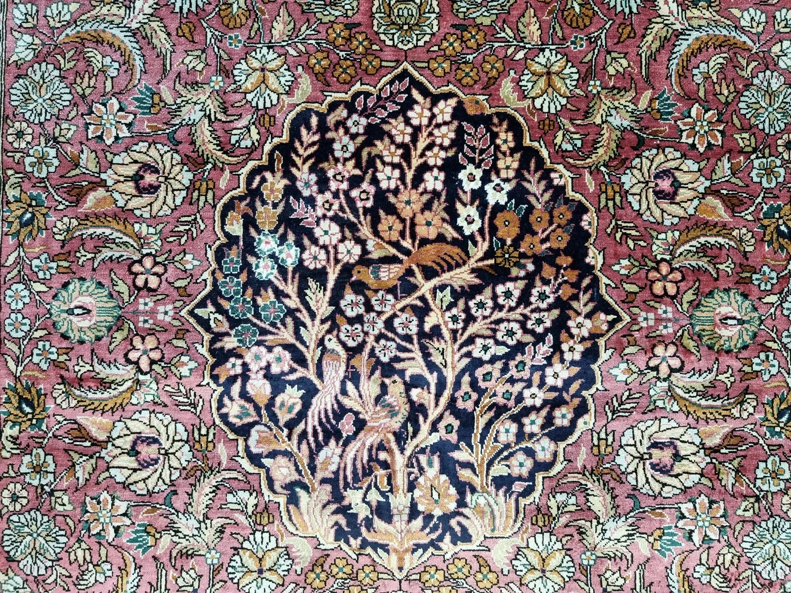 Handmade Chinese silk rug hanging on a wall for display.
