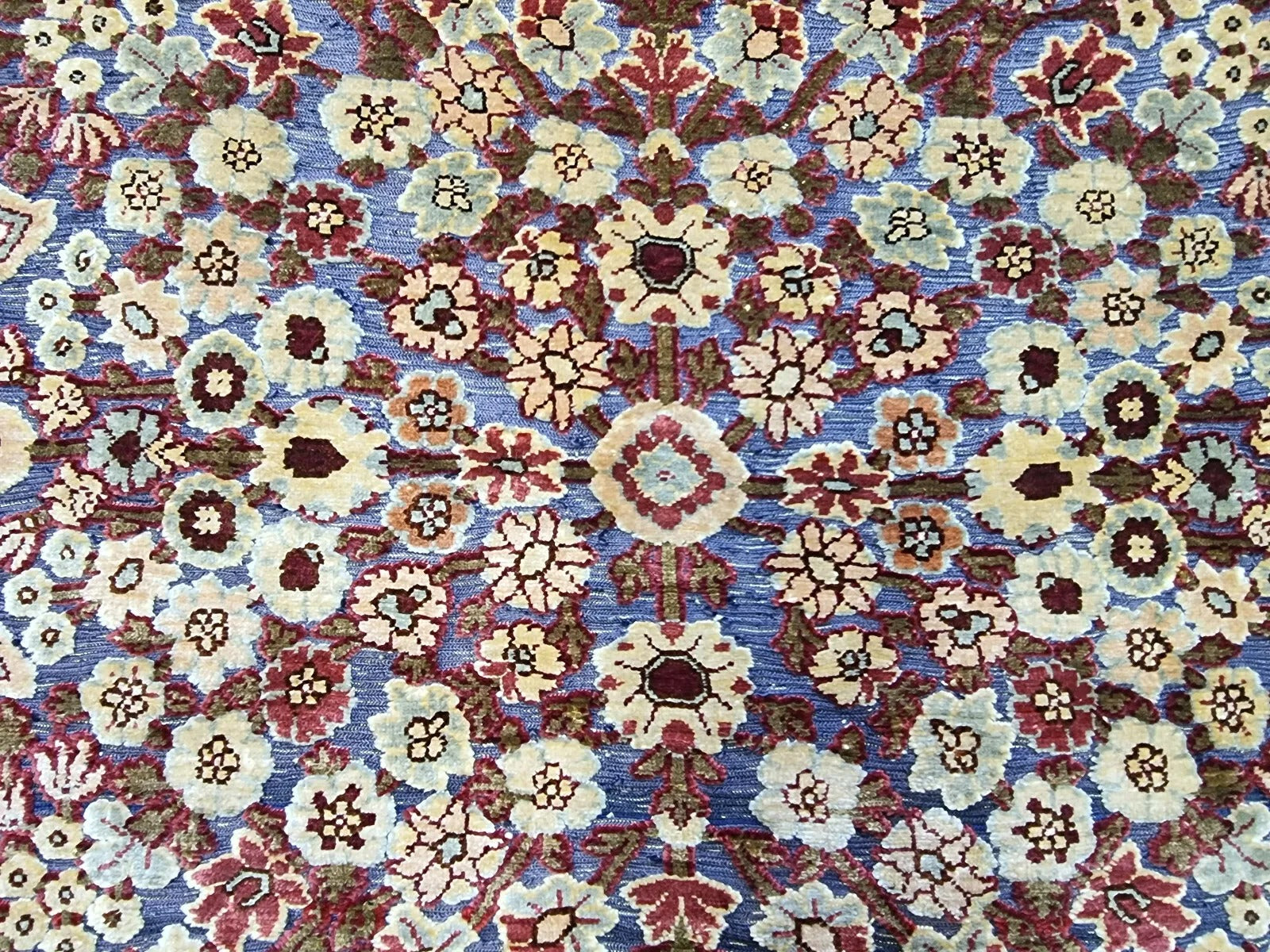 Close-up of hand-knotted silk details on a vintage Hereke rug.
