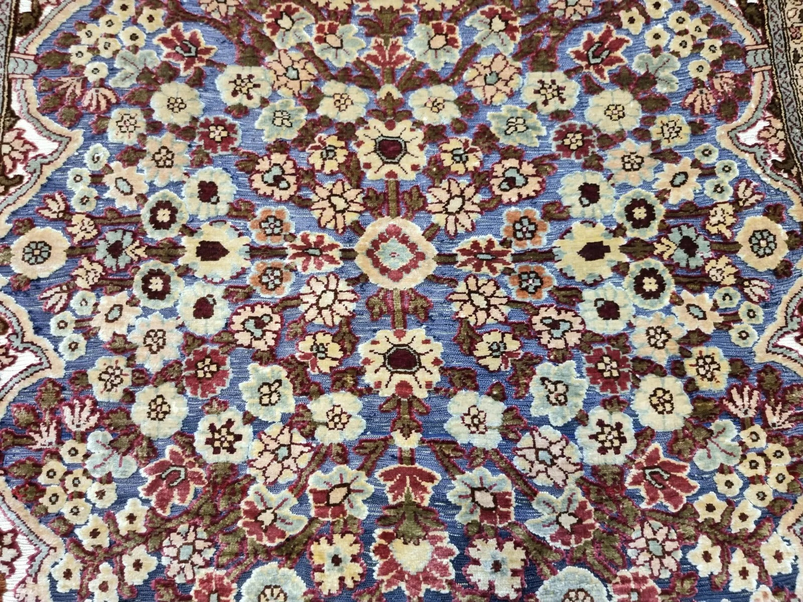Rectangular Hereke silk rug featuring classic floral motifs.
