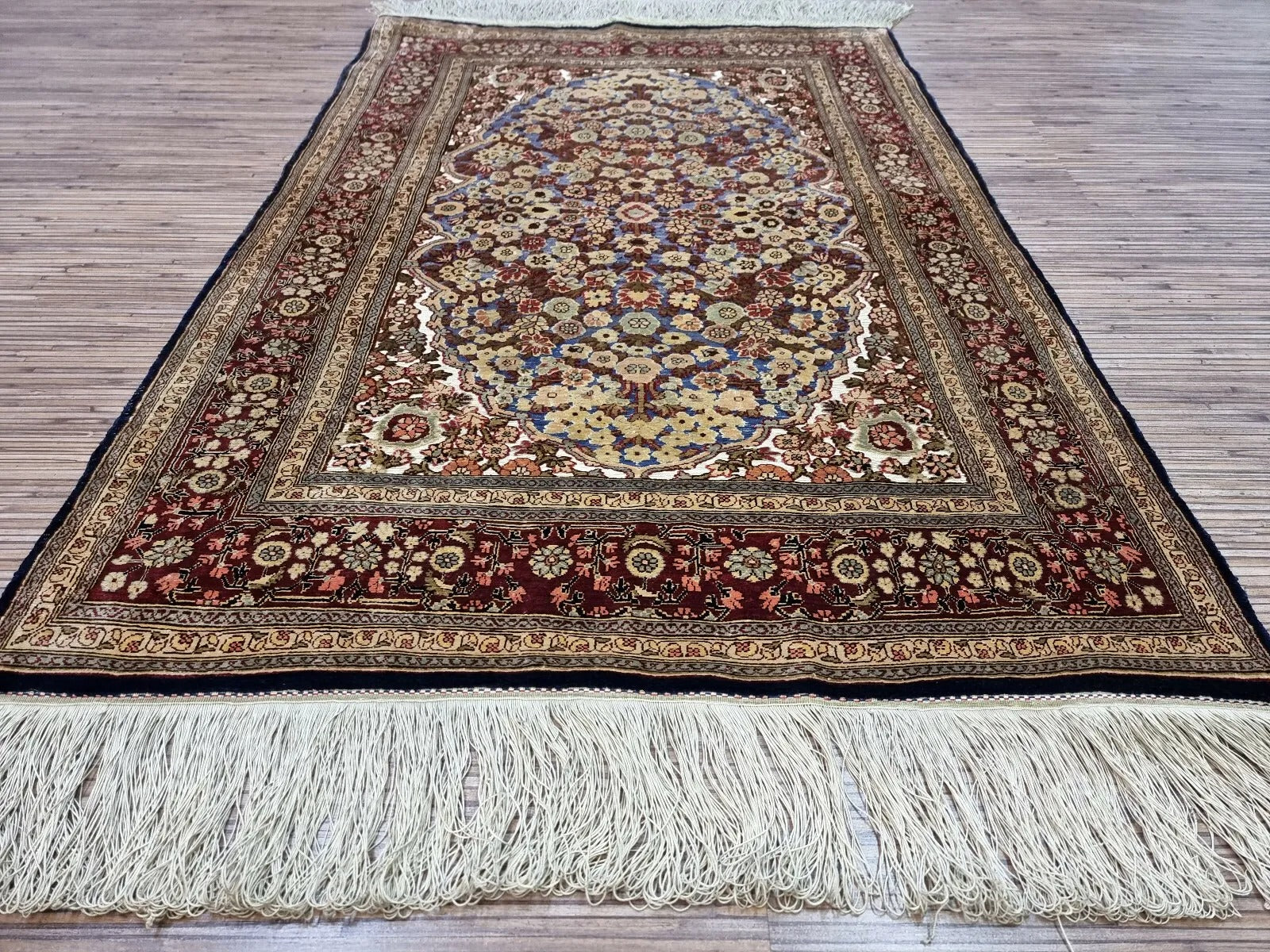 Multicolor silk rug with a balance of floral and geometric patterns.
