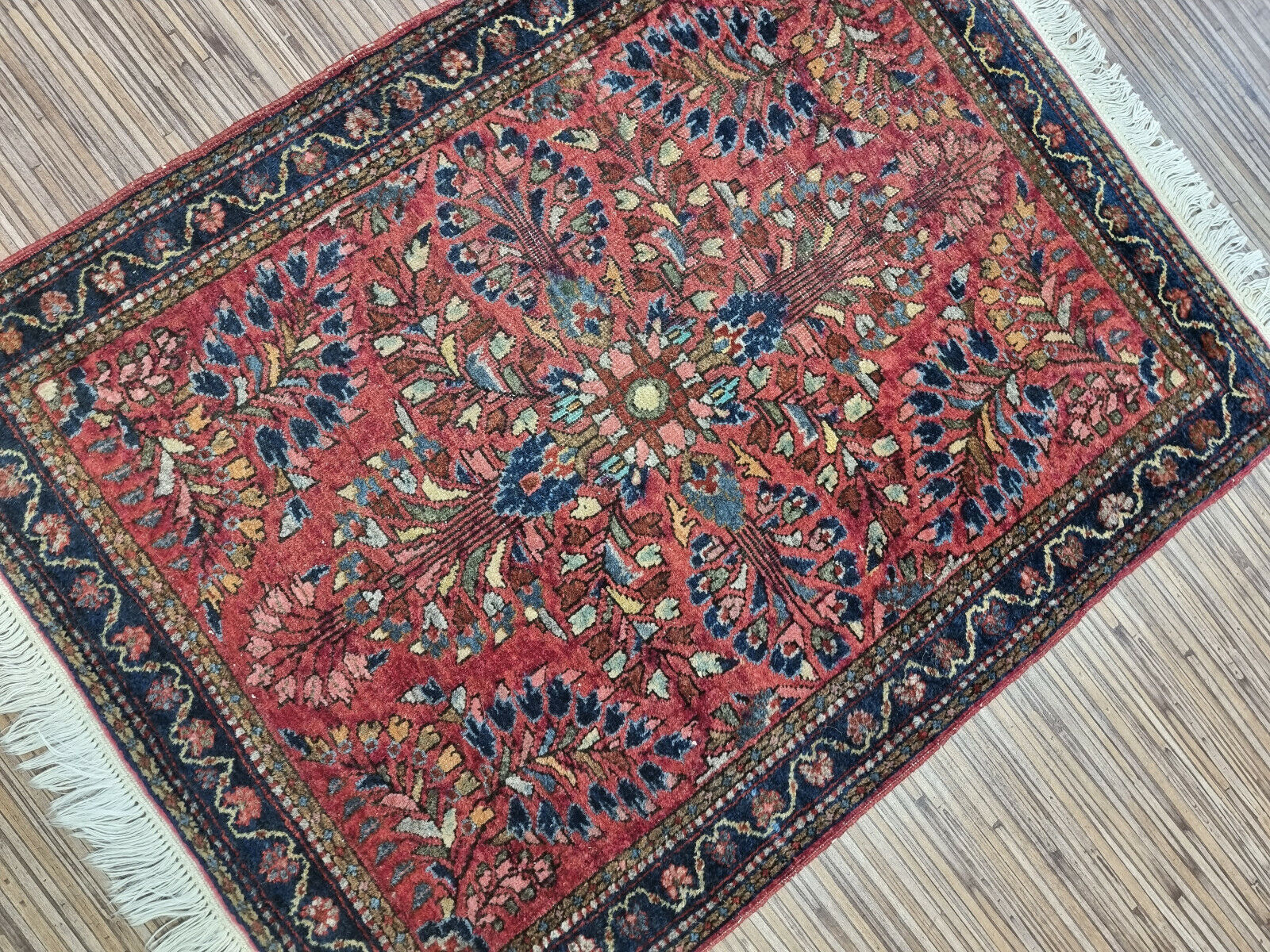 The rug’s aged patina, highlighting its historical charm and authenticity
