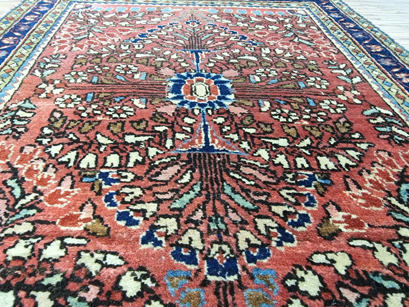 Rich red Persian-style rug with intricate traditional detailing
