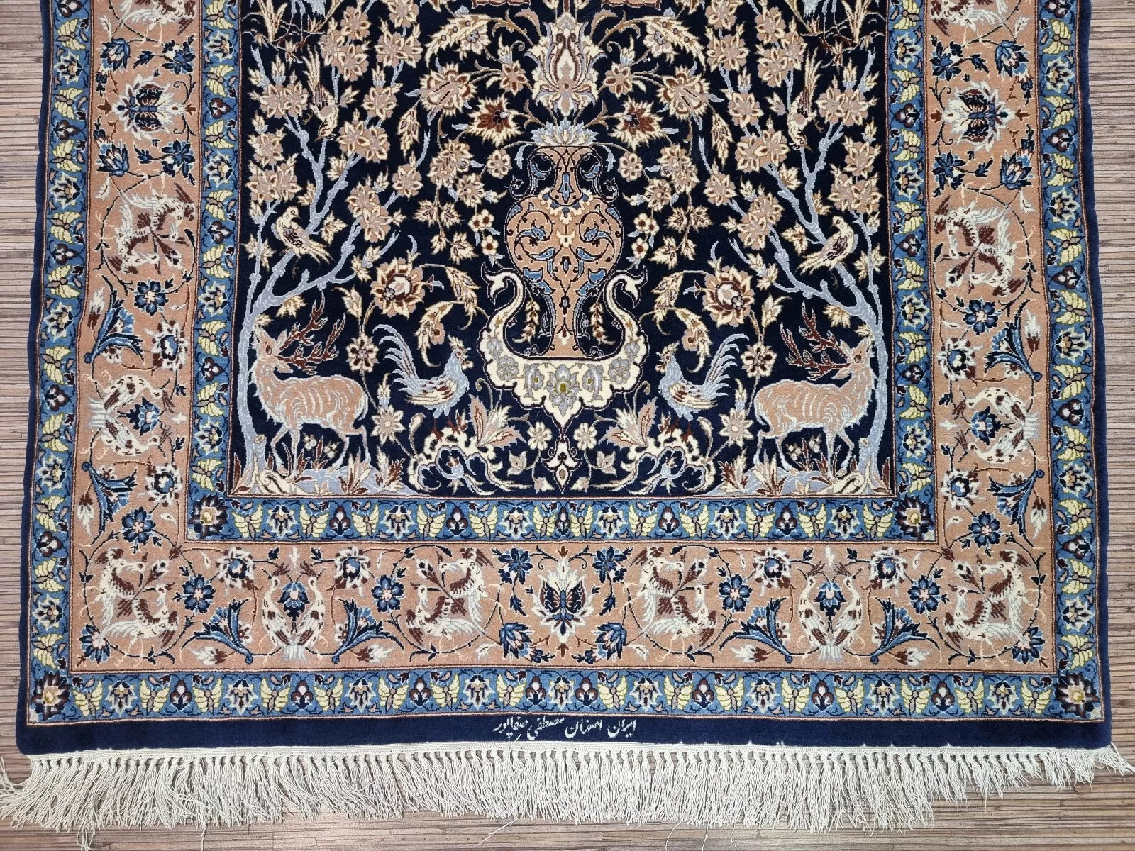 Detail of the artisan's signature woven into the field of the rug.


