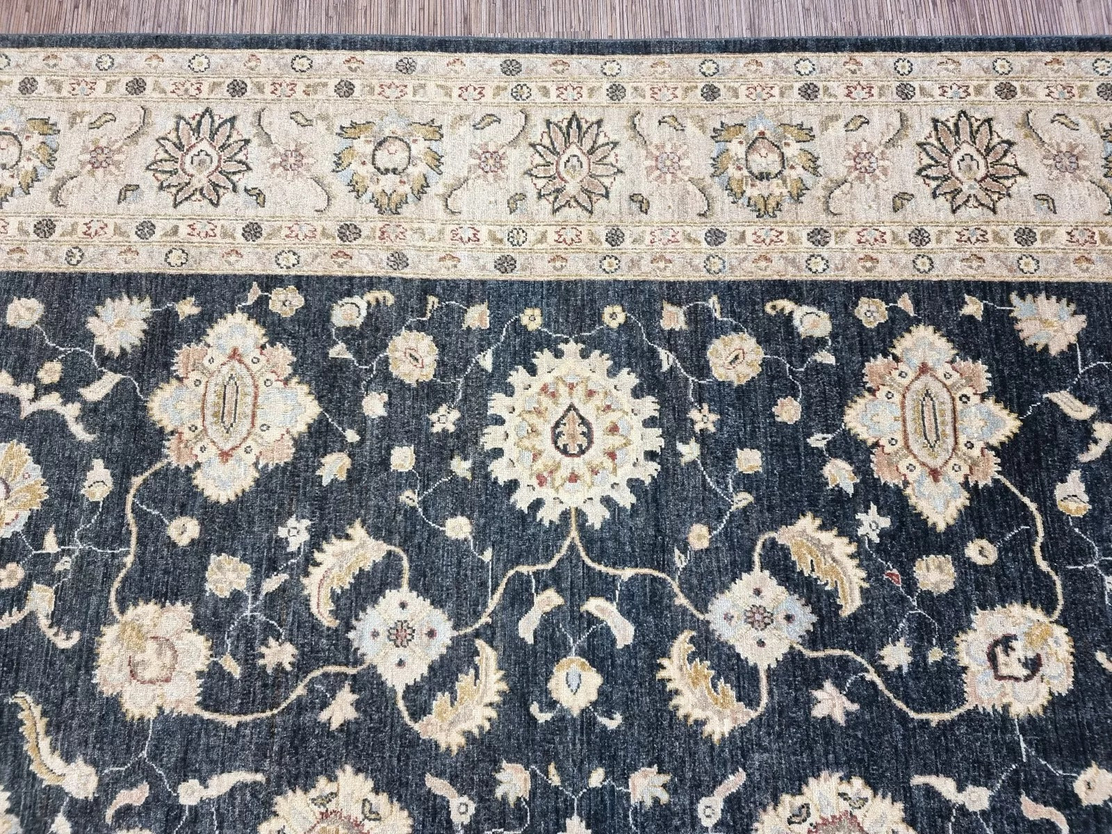 Close-up detail of an elegant floral medallion in deep black wool.

