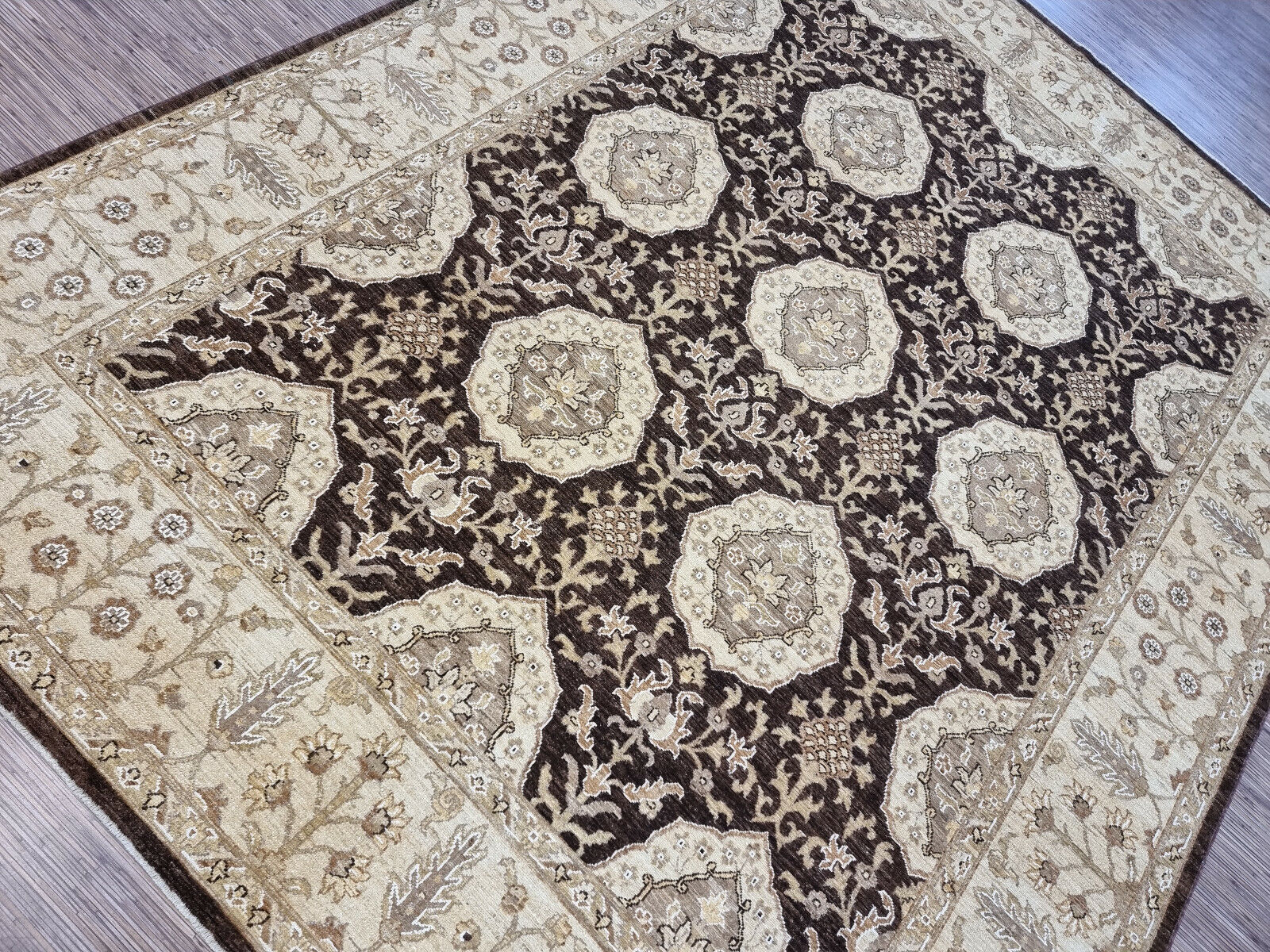 Shot focusing on the intricate vine and leaf motifs in a lighter brown tone.

