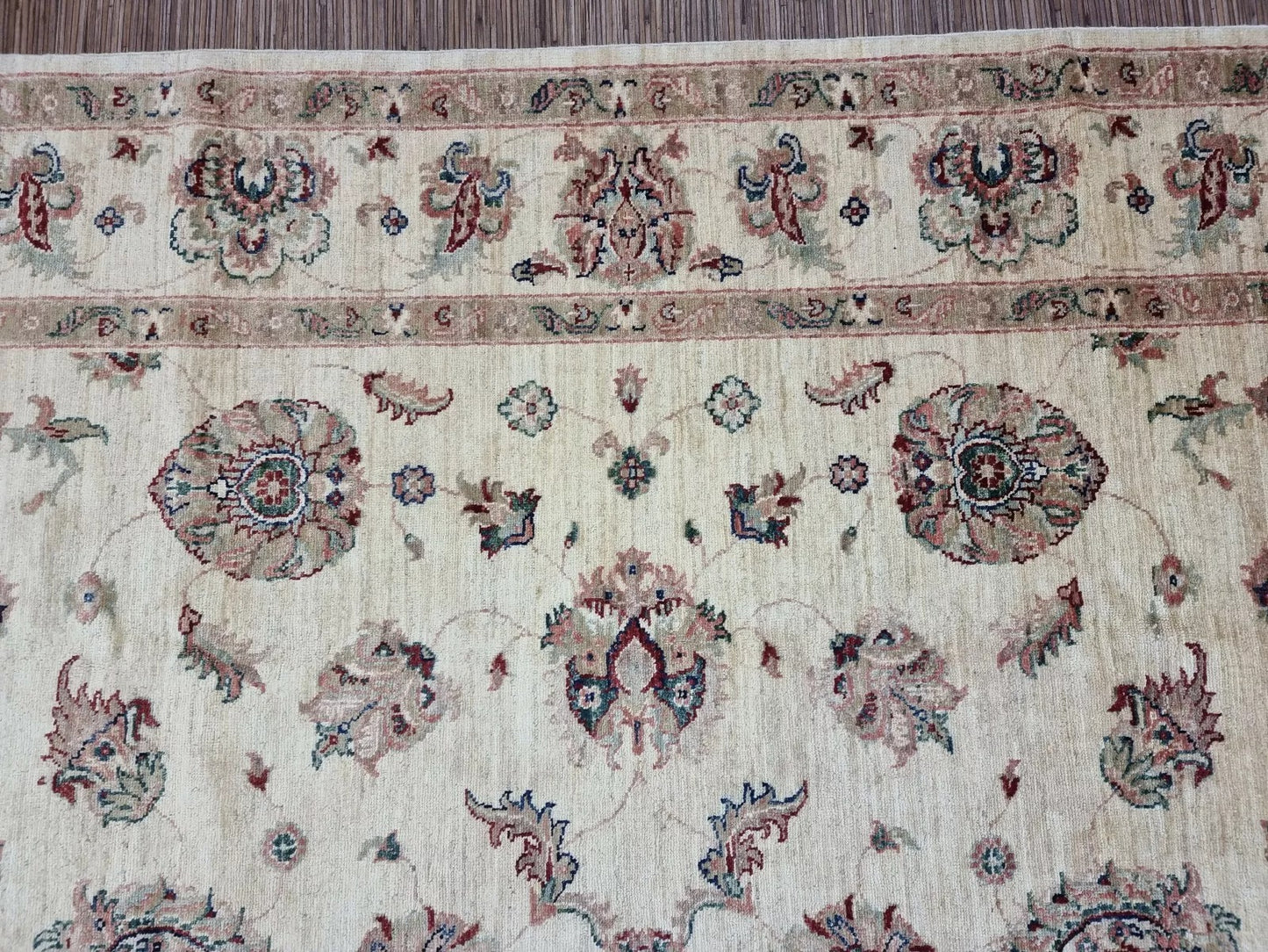 Detail of the light beige background color and the wool's textured surface.

