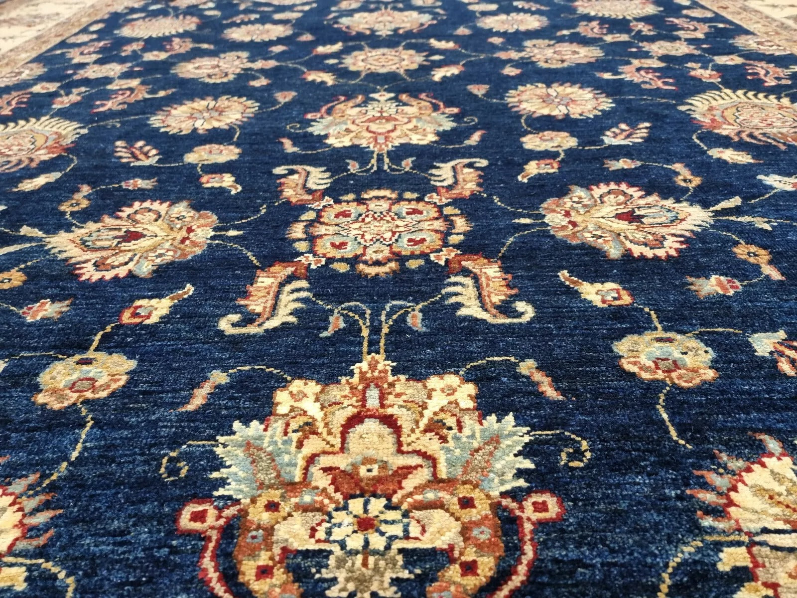 A section of the rug showcasing the rhythmic flow of the elegant floral motifs.

