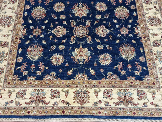 Close-up detail of a large floral medallion in deep navy blue wool.

