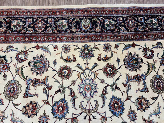 Close-up detail of an intricate palmette and floral motif in ivory and pink.

